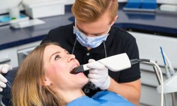 Dentist scanning the teeth of patient with a CEREC scanner
