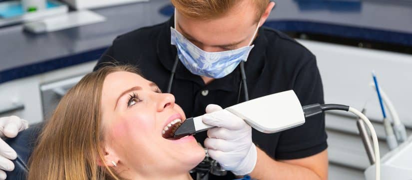 Dentist scanning the teeth of patient with a CEREC scanner